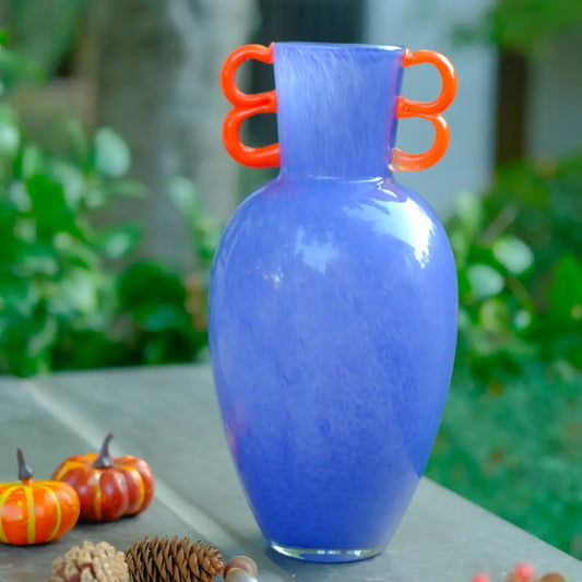 Vase violet en verre soufflé avec anses rouges ondulées, au design moderne et élégant.