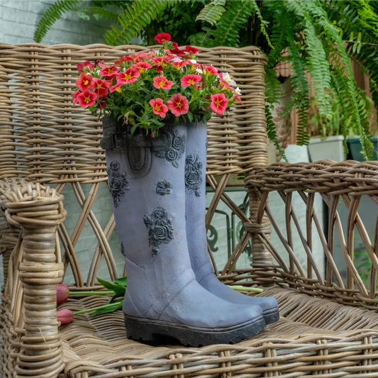 Pot de fleur pour extérieur – Bottes fleuries en résine décoratives affichées sur une chaise en osier.