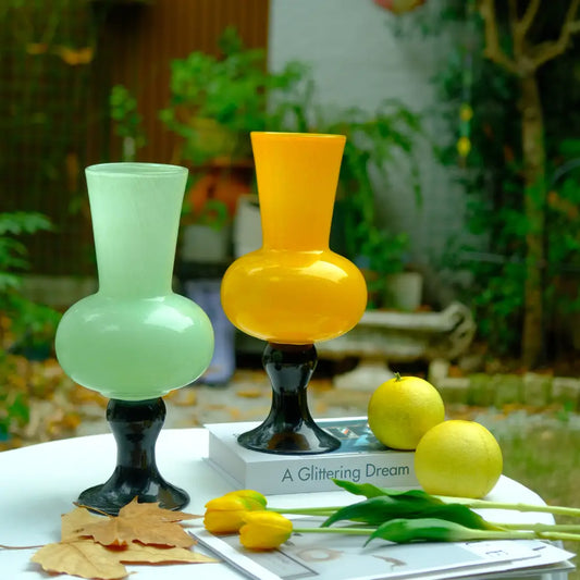 Vase coloré en verre soufflé, combinaison de jaune vif et vert menthe sur pied noir.