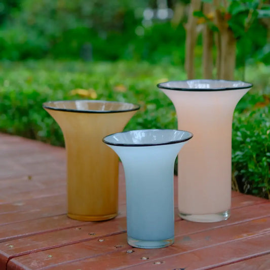 Vase pour tulipes en verre soufflé, aux teintes douces de rose, ambre et bleu clair.