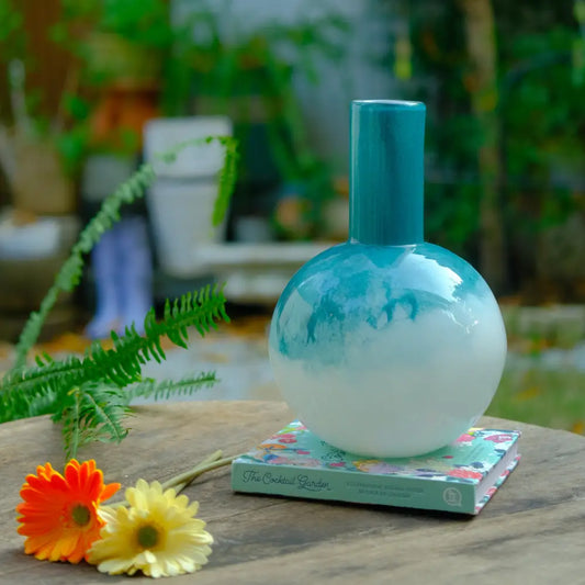 Vase bombé artisanal en verre, base sphérique et finition bleu dégradé élégante.
