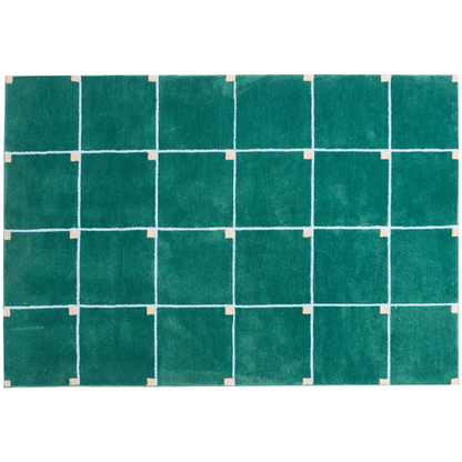 Salon minimaliste décoré d’un tapis à carreaux vert, ajoutant une texture douce et un style graphique à la pièce.
