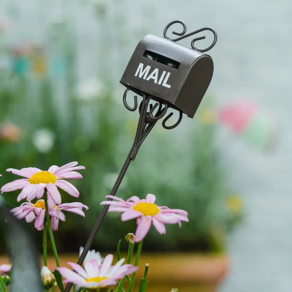 Decoration pot de fleurs - Pique décoratif en forme de boîte aux lettres dans un jardin avec des fleurs.