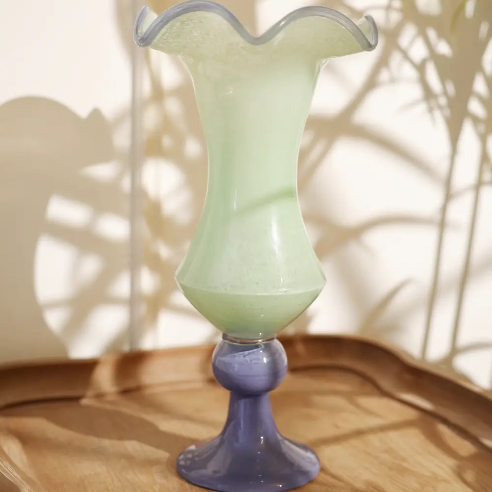 Decorative vases en verre soufflé vert pâle avec base bleue, au col ondulé élégant.