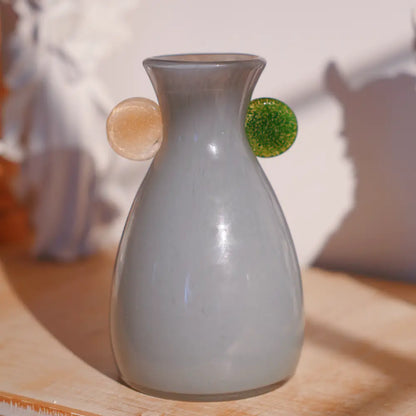 Décorer vase en verre gris soufflé, orné de deux pastilles colorées vert et doré au style moderne.