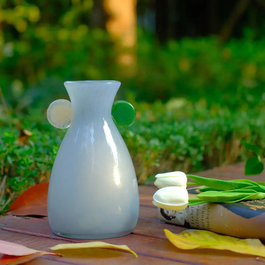 Décorer vase en verre soufflé gris clair avec pastilles vertes et transparentes pour un style moderne.