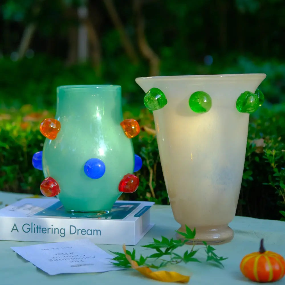 Grand vase en verre soufflé beige avec motifs verts arrondis, idéal pour une décoration moderne.
