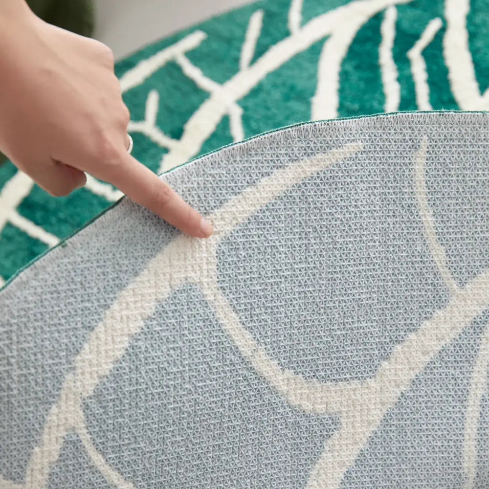 Tapis vert lavable dans un coin détente, complétant les tons naturels du canapé et des plantes.