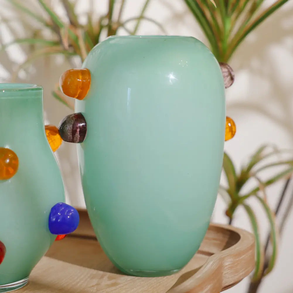 Grand vase vert en verre soufflé avec décorations latérales ambrées et grises, idéal pour un intérieur contemporain.