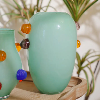 Grand vase vert en verre soufflé avec décorations latérales ambrées et grises, idéal pour un intérieur contemporain.