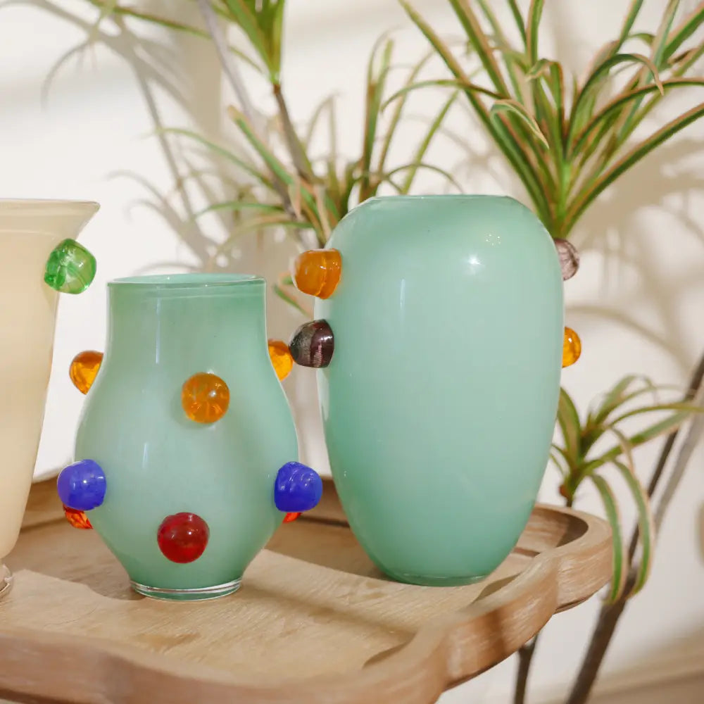 Grand vase au design moderne en verre vert pastel, orné de pastilles en relief de couleur ambre et grise.