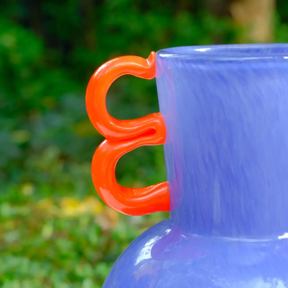 Vase violet en verre soufflé au col étroit et aux lignes harmonieuses.