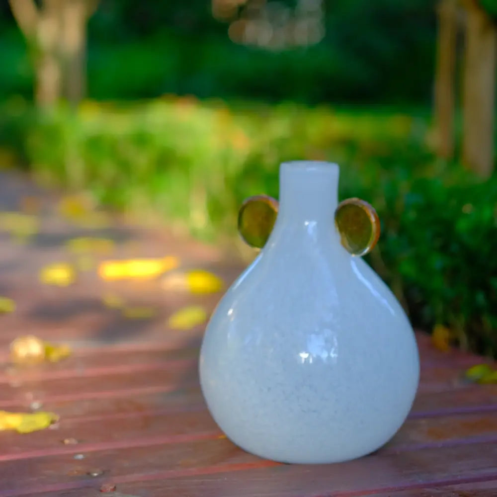 Mini vase blanc rond décoré d’oreilles en verre ambré, parfait pour une touche moderne.