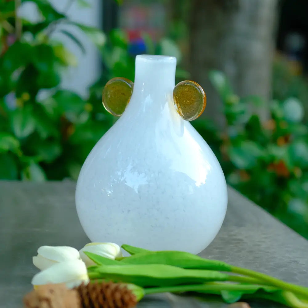 Mini vase blanc en verre soufflé avec pastilles ambrées, au design minimaliste et moderne.