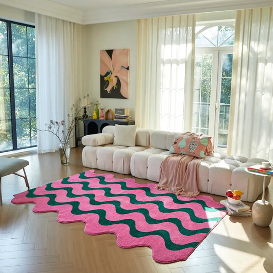 Grand tapis ondulé rose et vert placé devant un canapé crème, idéal pour créer une atmosphère chaleureuse et design.