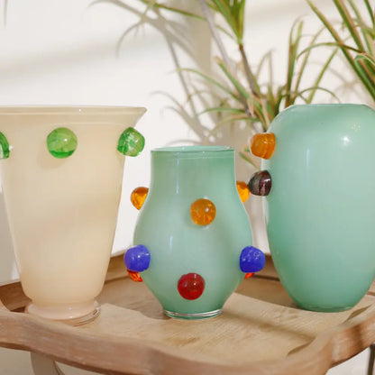 Petit vase en verre soufflé à motifs en relief multicolores, parfait pour ajouter une touche artistique à une étagère ou une table.