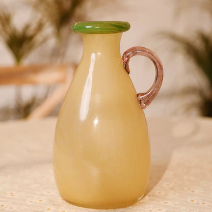 Petit vase en verre ambré avec anse violette et col vert, au design minimaliste et élégant.