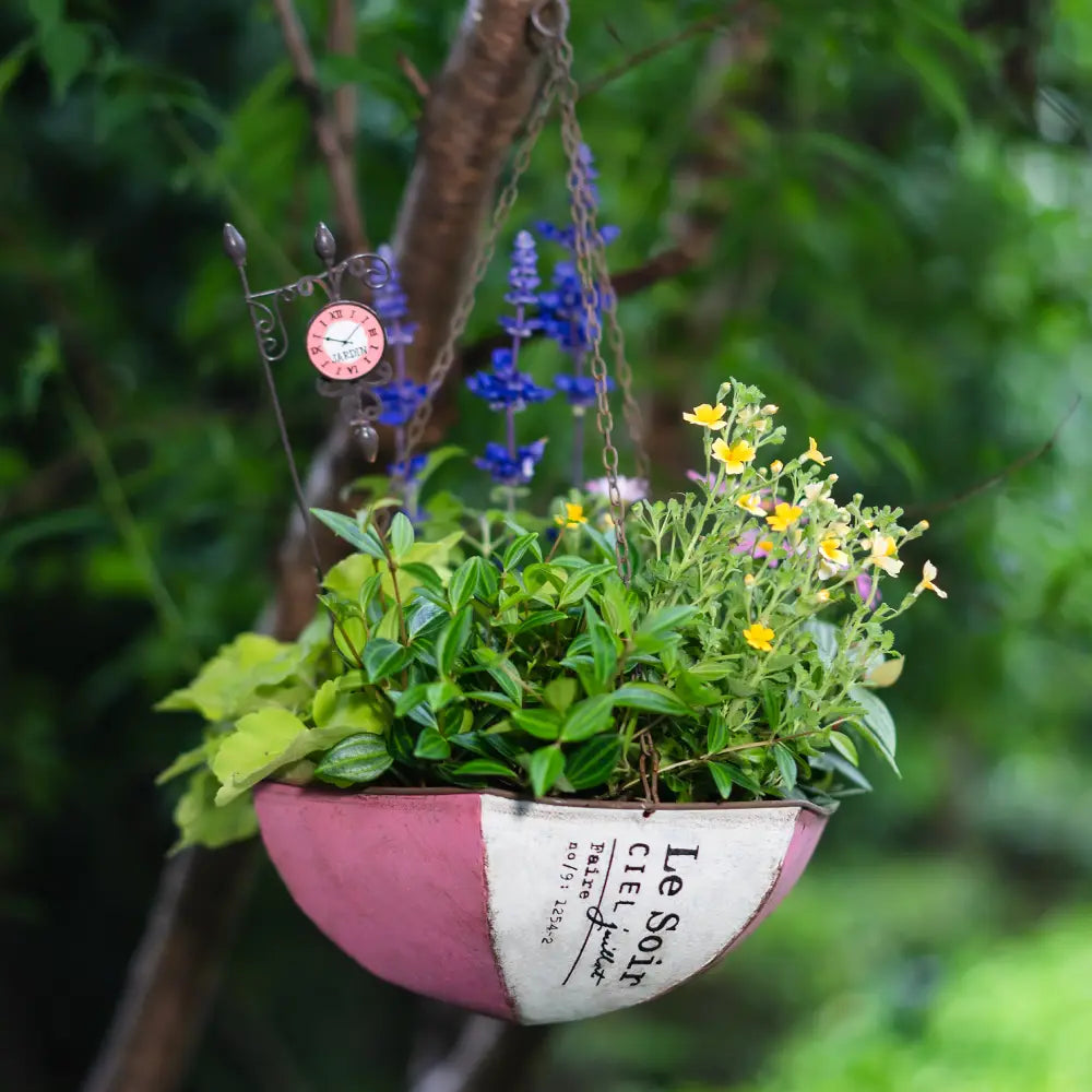 Pot de fleur à suspendre – Déco de jardin avec fleurs colorées dans un pot en métal vieilli.