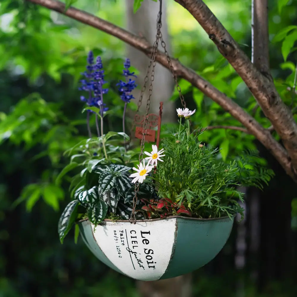 Pot de fleur à suspendre – Demi-umbrella en métal vieilli avec des fleurs colorées.