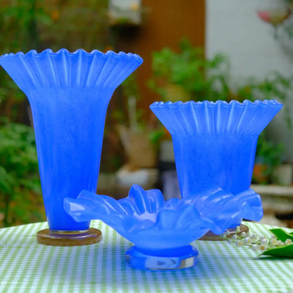 Vase bleu en verre soufflé avec bord ondulé, au style artistique et contemporain.
