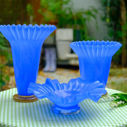 Vase bleu en verre soufflé au design plissé, création artisanale lumineuse et moderne.