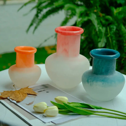 Vase décoratif en verre coloré, aux teintes corail, bleu et rose poudré.