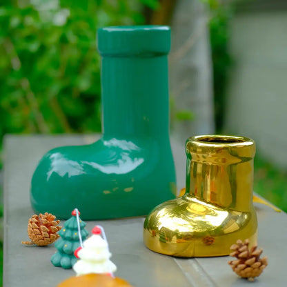 Vase décoré en céramique en forme de botte, aux finitions vert émeraude et doré, parfait pour une décoration originale et festive dans le salon ou sur la table.
