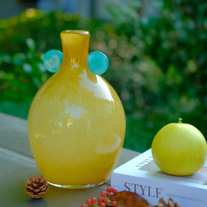 Vase jaune décoratif en verre artisanal, orné de détails bleus pour une touche contemporaine.