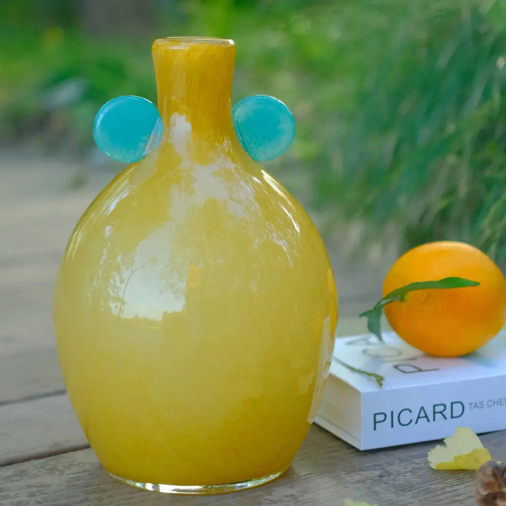 Vase jaune en verre soufflé avec pastilles vertes, au design lumineux et artisanal.