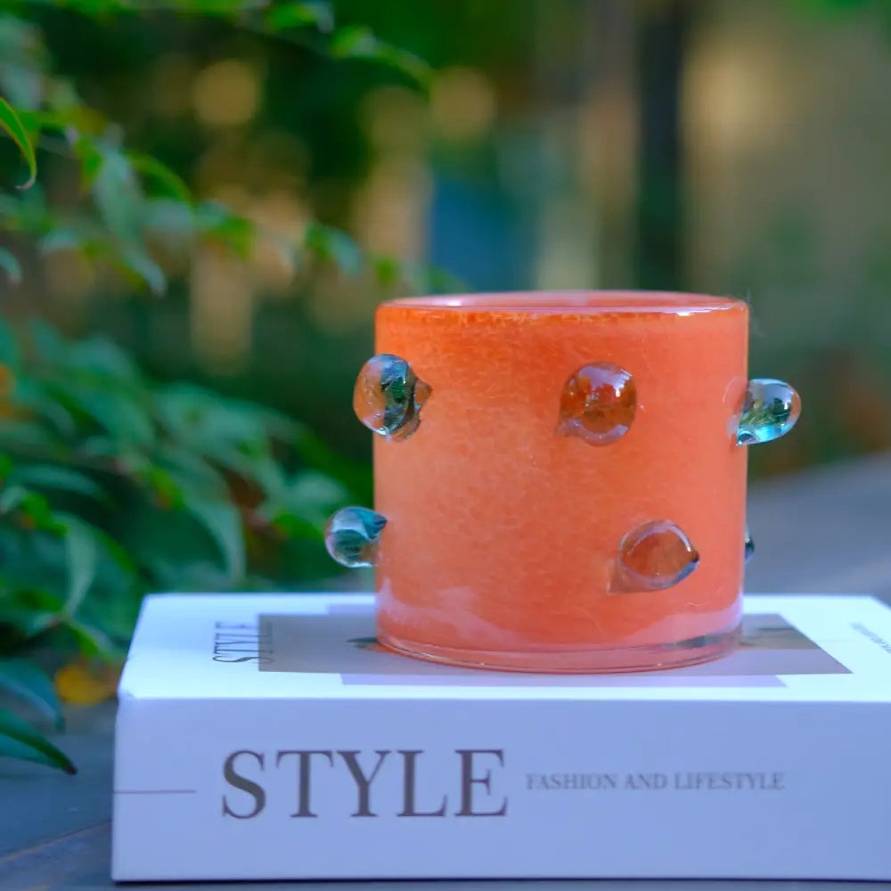 Vase orange en verre soufflé avec détails verts, design original et artistique.