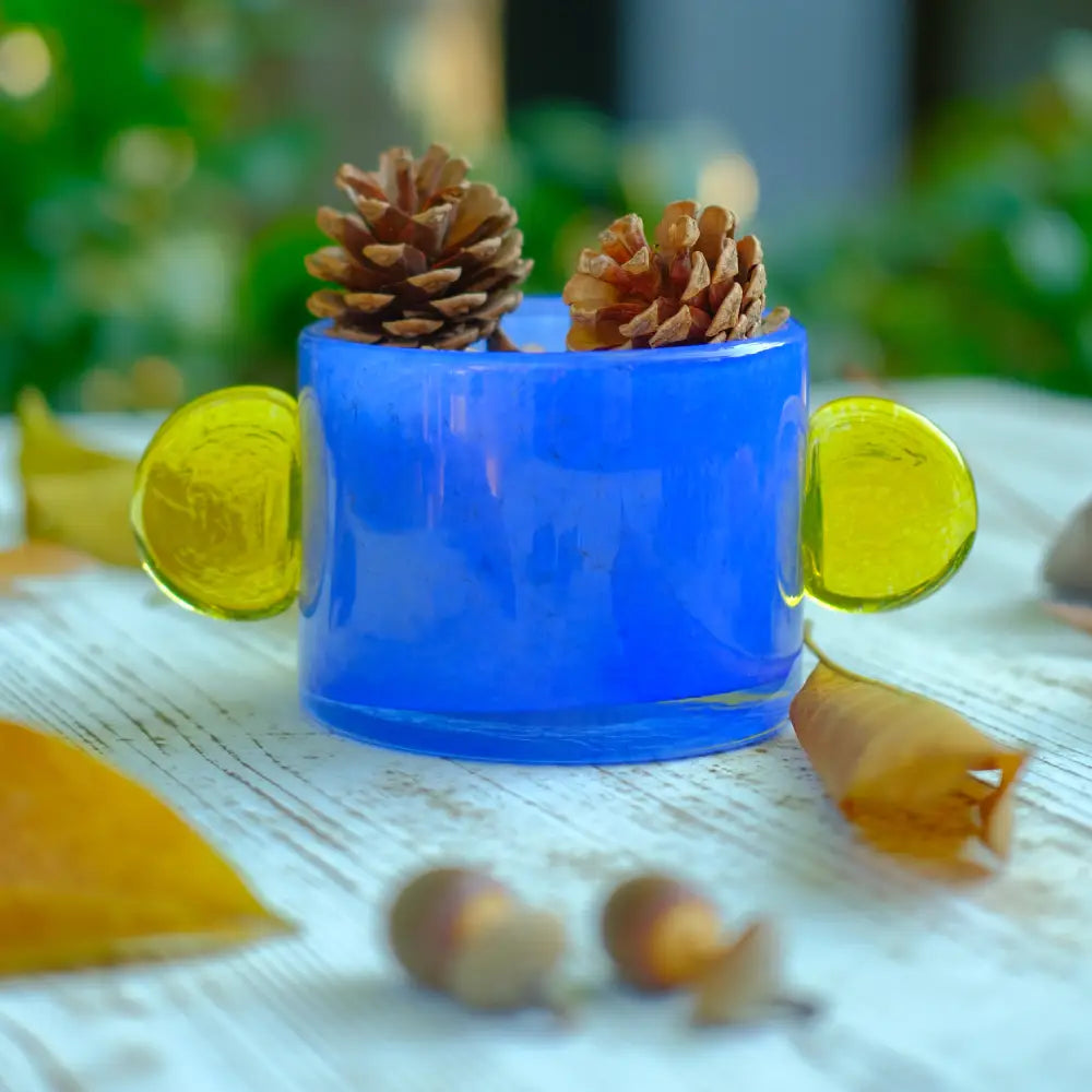 Vase bleu cylindrique décoré de disques jaunes, pièce artisanale originale.