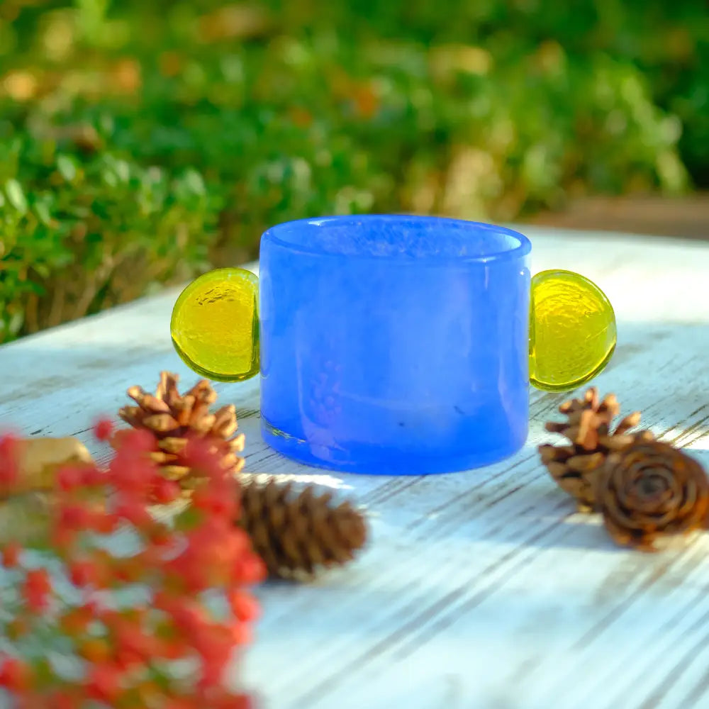 Vase bleu en verre soufflé avec pastilles jaunes, au design moderne et lumineux.