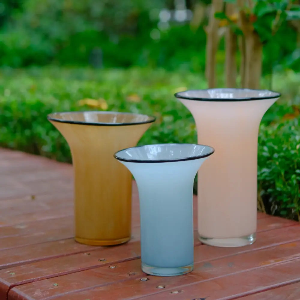 Vase pour tulipes en verre soufflé, aux teintes douces de rose, ambre et bleu clair.