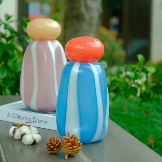 Vase rayé en verre soufflé bleu et blanc, au design moderne et lumineux.