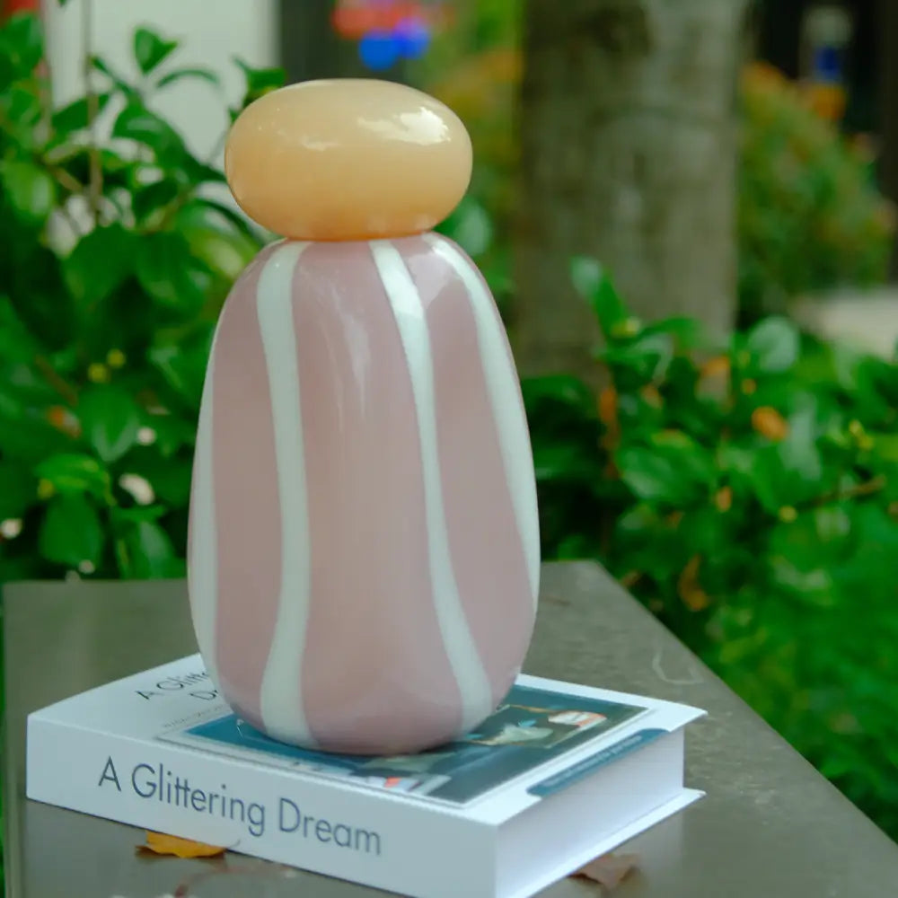 Vase rayé en verre décoratif, combinaison de lignes fluides et de teintes pastel élégantes.