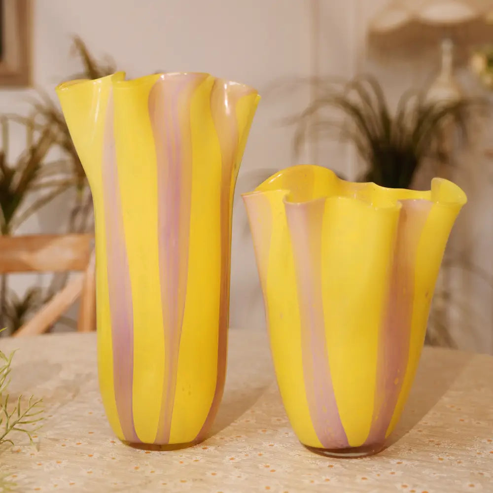 Vase rayures en verre soufflé jaune et violet, au col ondulé et à la forme élancée.