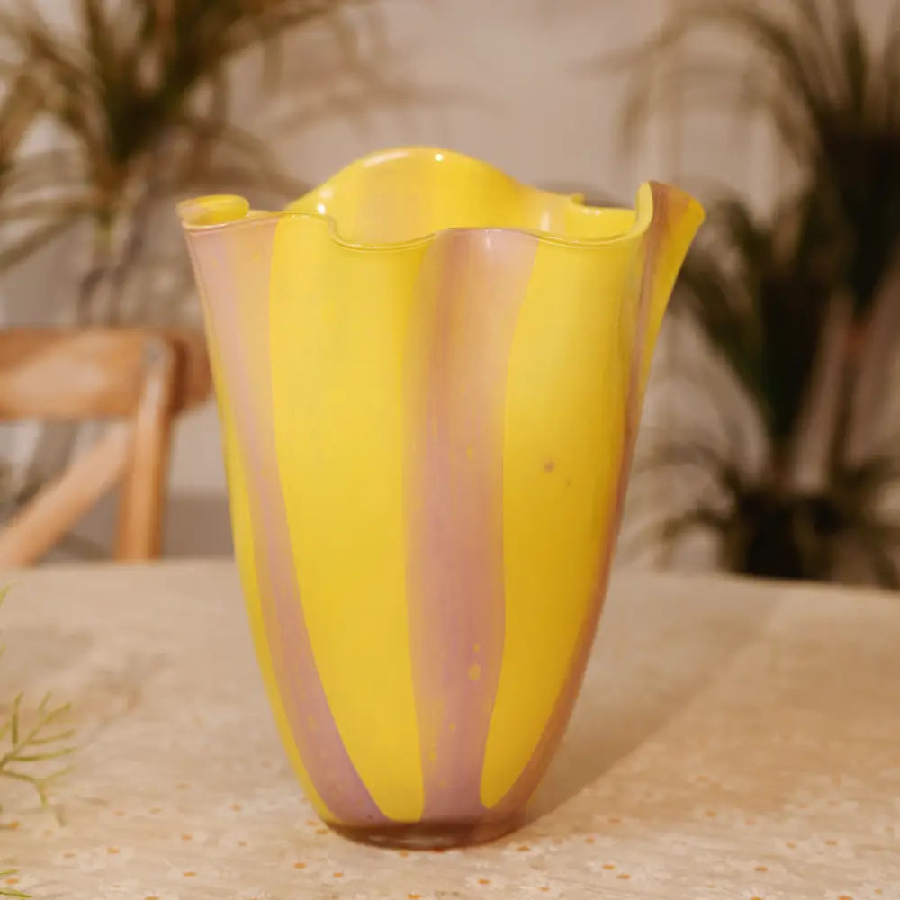 Vase rayures design aux tons lumineux de jaune et de lavande, parfait pour un intérieur moderne.