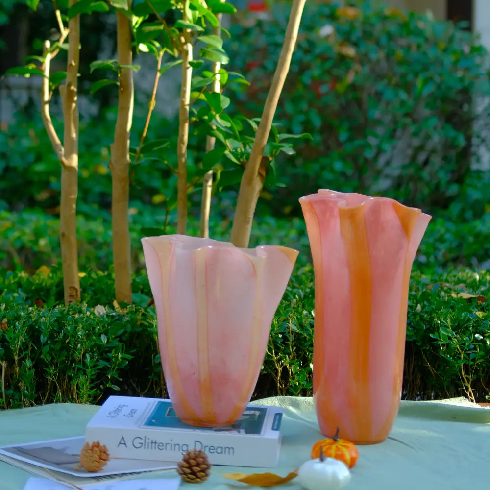 Vase design haut en verre rose, décoré de courbes orange pour un style contemporain.