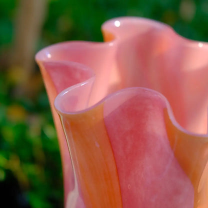 Vase design en verre soufflé rose et orange, à bord évasé rappelant des pétales de fleur.
