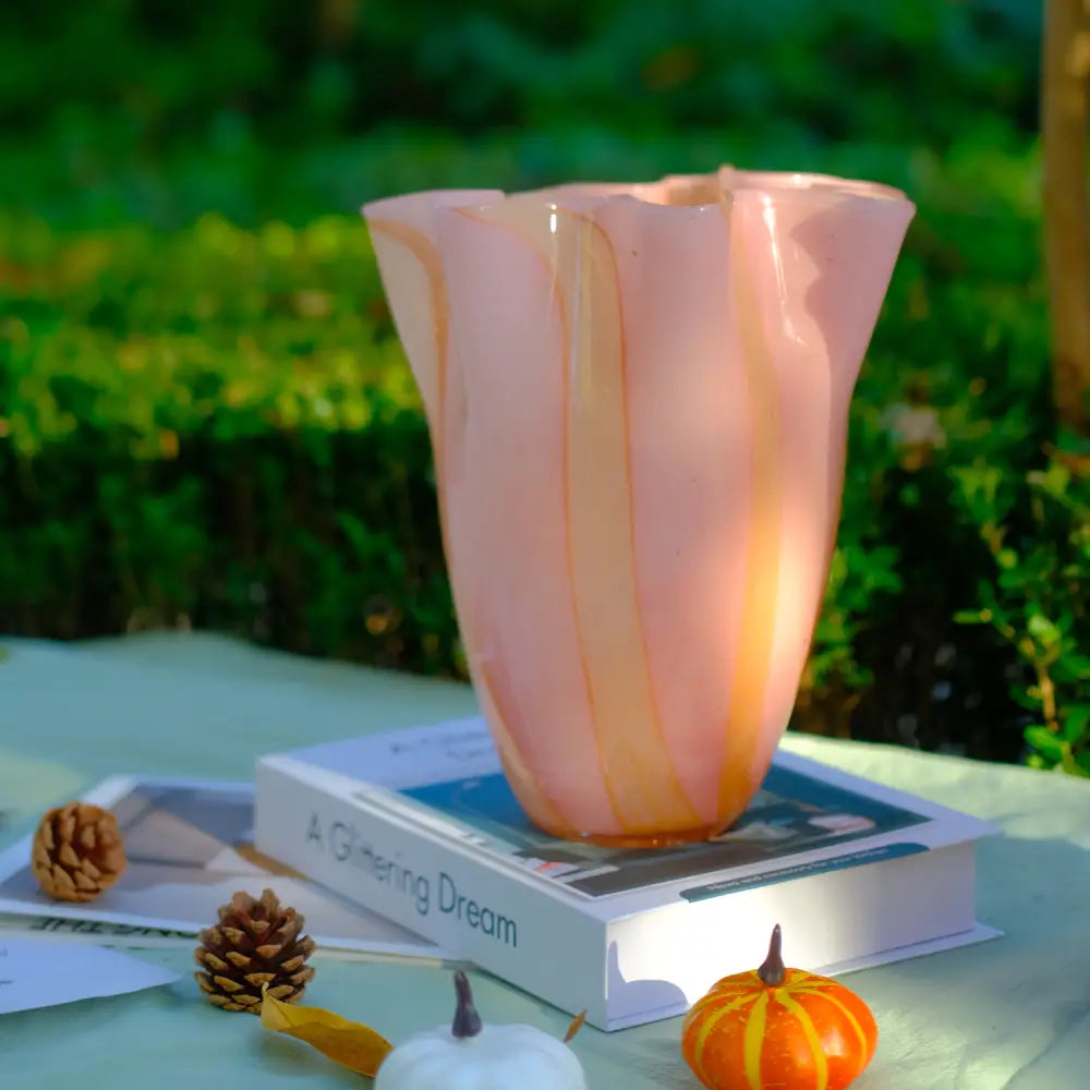 Vase design rose à rayures orange, silhouette organique idéale pour une décoration moderne.