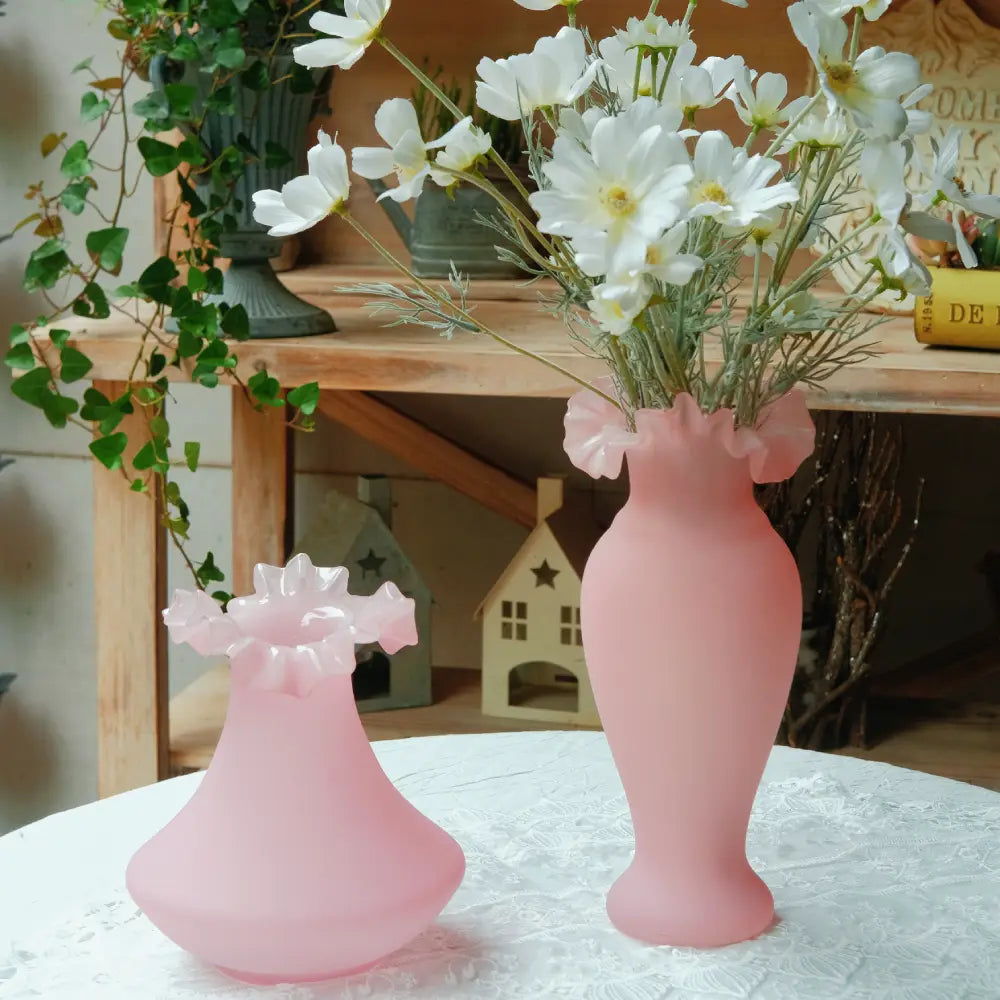 Duo de vases roses en verre soufflé, modèles assortis parfaits pour une décoration vintage ou romantique.