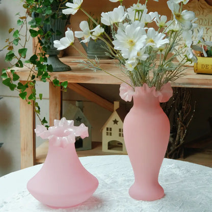 Duo de vases roses en verre soufflé, modèles assortis parfaits pour une décoration vintage ou romantique.