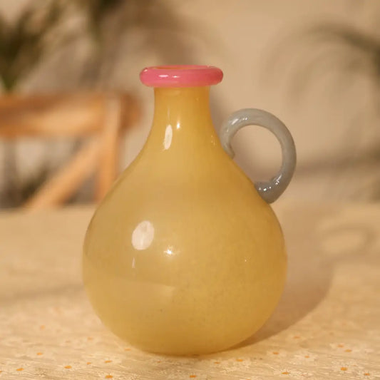 Vase soliflore décoratif de couleur miel avec poignée courbée et bord rose, parfait pour une fleur unique.