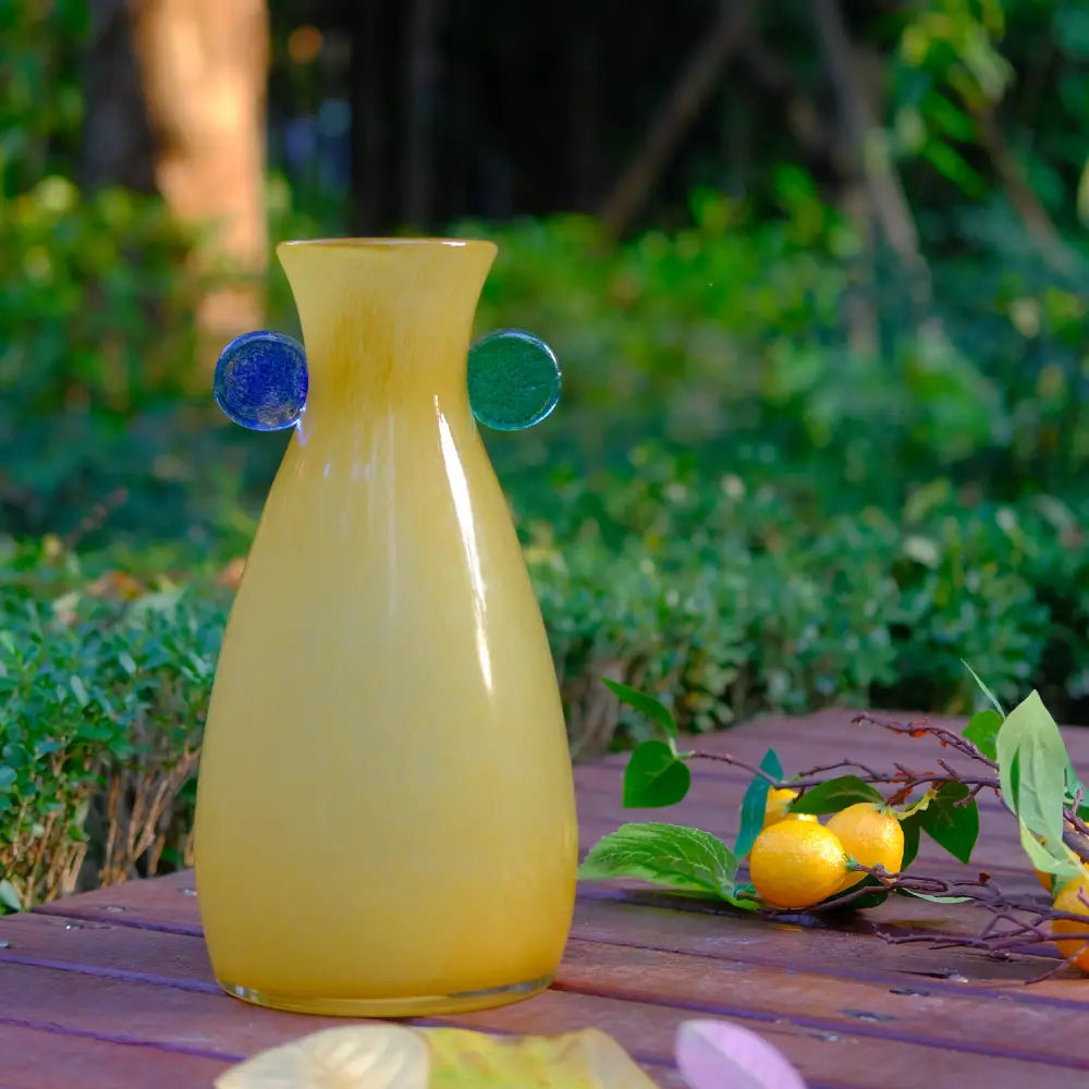 Vase verre original en ton ambre, décoré de pastilles bleues et vertes pour un style unique.