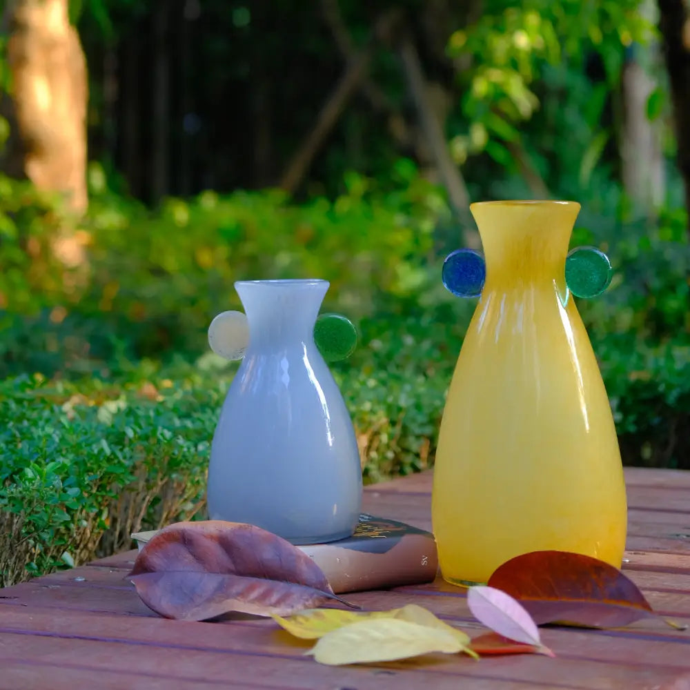 Vase verre original jaune avec détails bleus et verts, pièce design idéale pour la décoration intérieure.