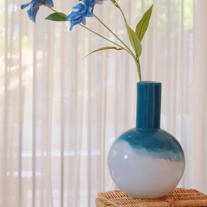 Vase bombé design bleu boréal avec fleurs séchées, accessoire décoratif élégant pour salon ou chambre lumineuse.