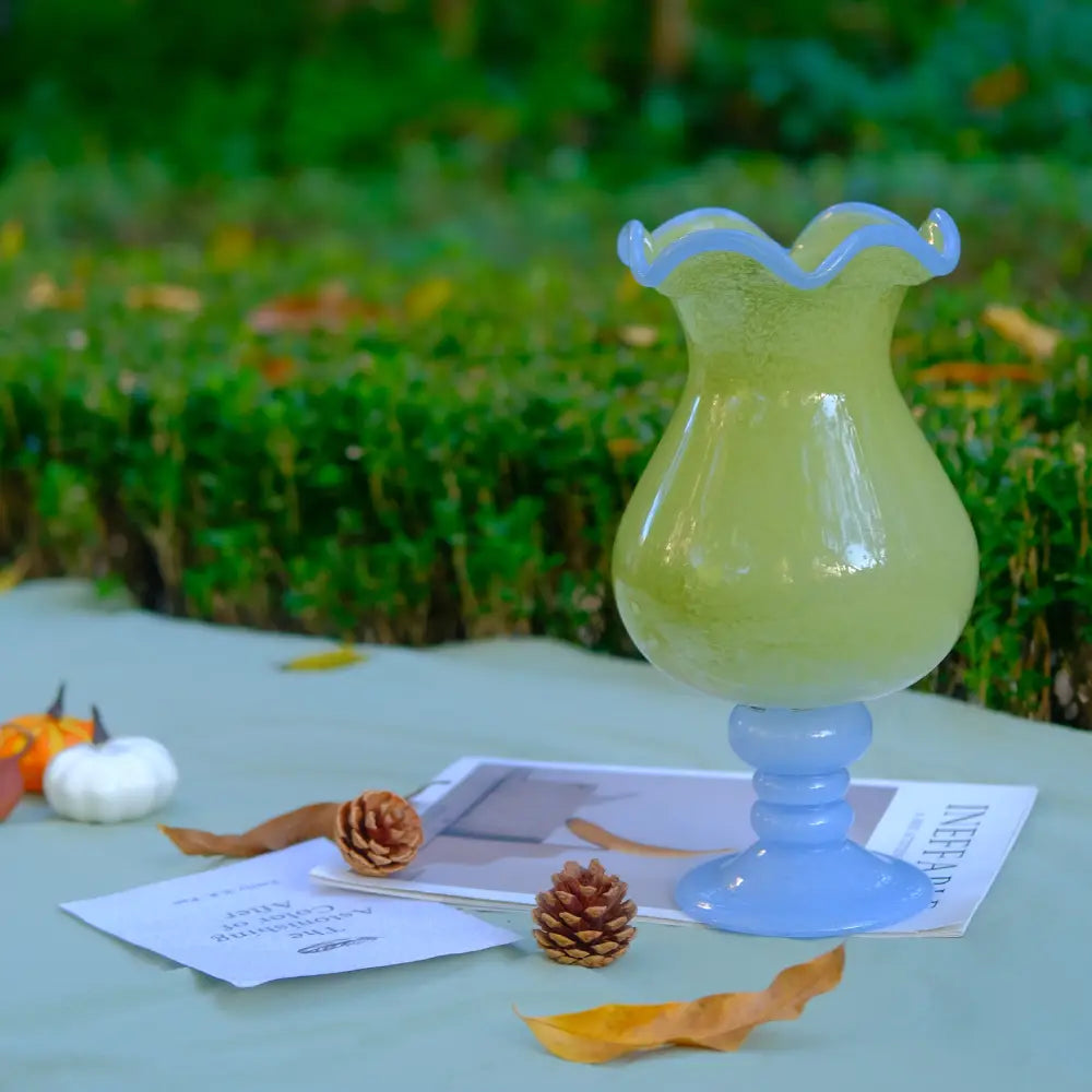 Vase with design en verre coloré, forme courbée et pied contrasté pour une déco originale.