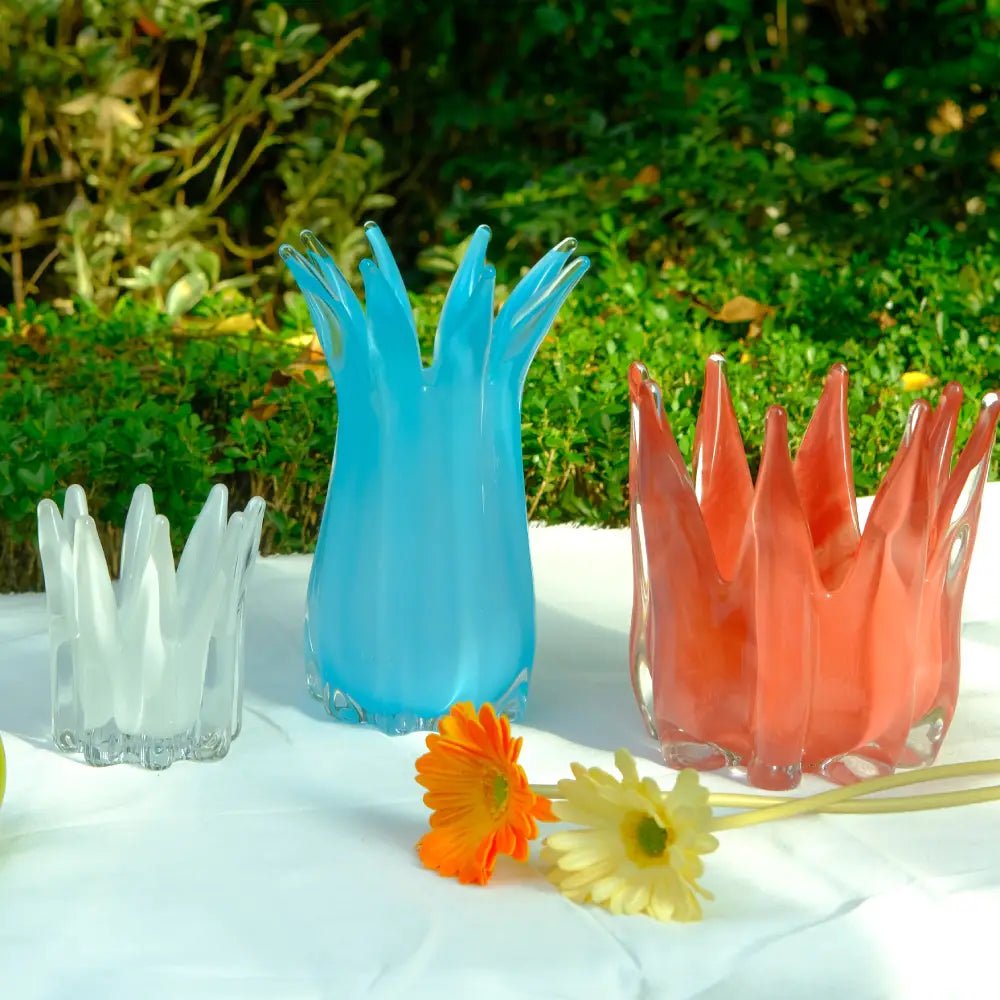 Vases et fleurs design en verre soufflé, aux couleurs bleu, blanc et rouge éclatantes.