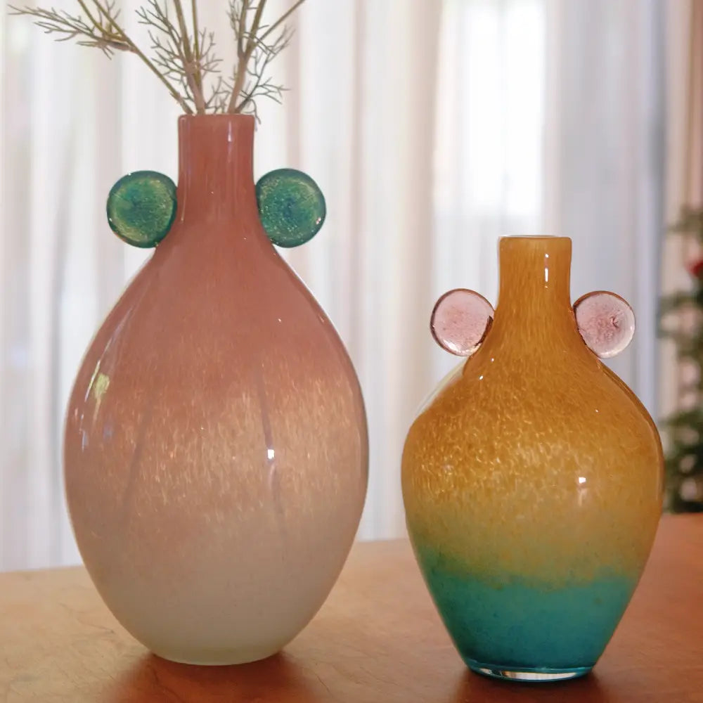 Duo de vases boule en verre soufflé artisanal, aux nuances framboise menthe et mangue océan, parfaits pour une décoration contemporaine et lumineuse.