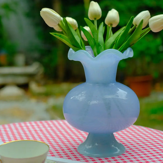 Vase artisanal en verre bleu, forme arrondie et texture lumineuse.